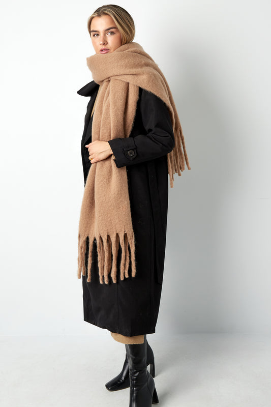 ​Model med camel-farvet halstørklæde med elegante frynser, nonchalant draperet over skuldrene – varm luksus til kølige dage.​