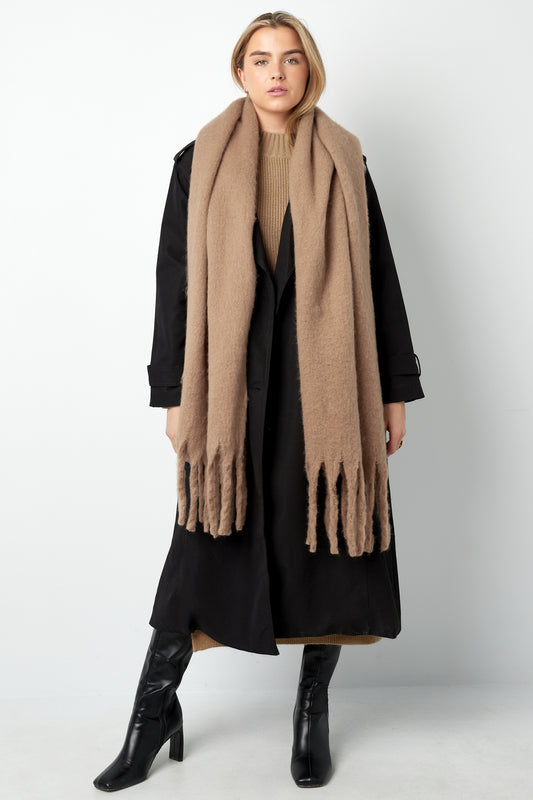 Modelbillede af det bløde, camel-farvede stof og de delikate frynser – en sanselig oplevelse af komfort og stil.