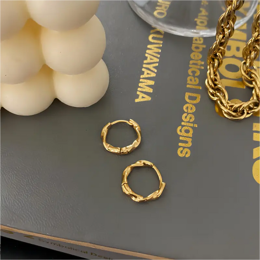 Snoede hoops i guldbelagt rustfrit stål med unik bølget struktur – elegant design fra SpohrCopenhagen.