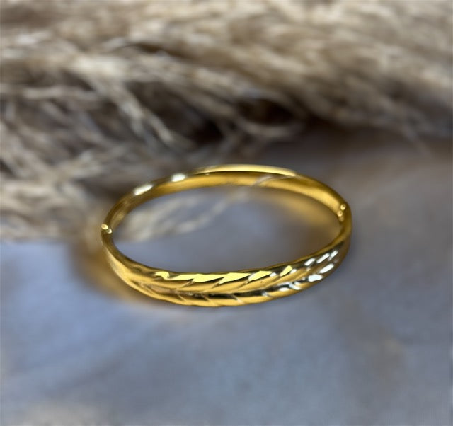 Nærbillede af armbåndets flettede mønster – et spil mellem lys og skygge, der giver dit look vinger.