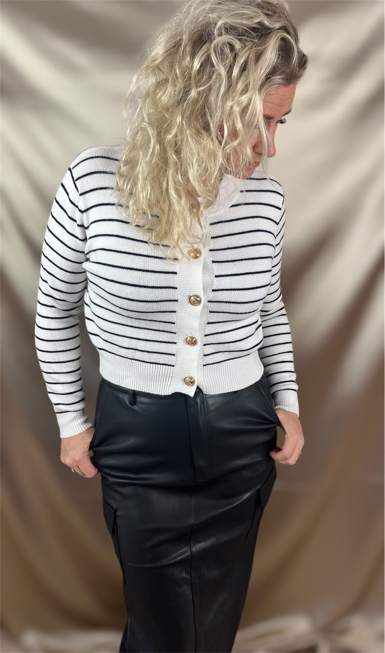 ​Model kombinerer cardiganen med en sort nederdel for et sofistikeret look – tidløs stil med moderne kant.