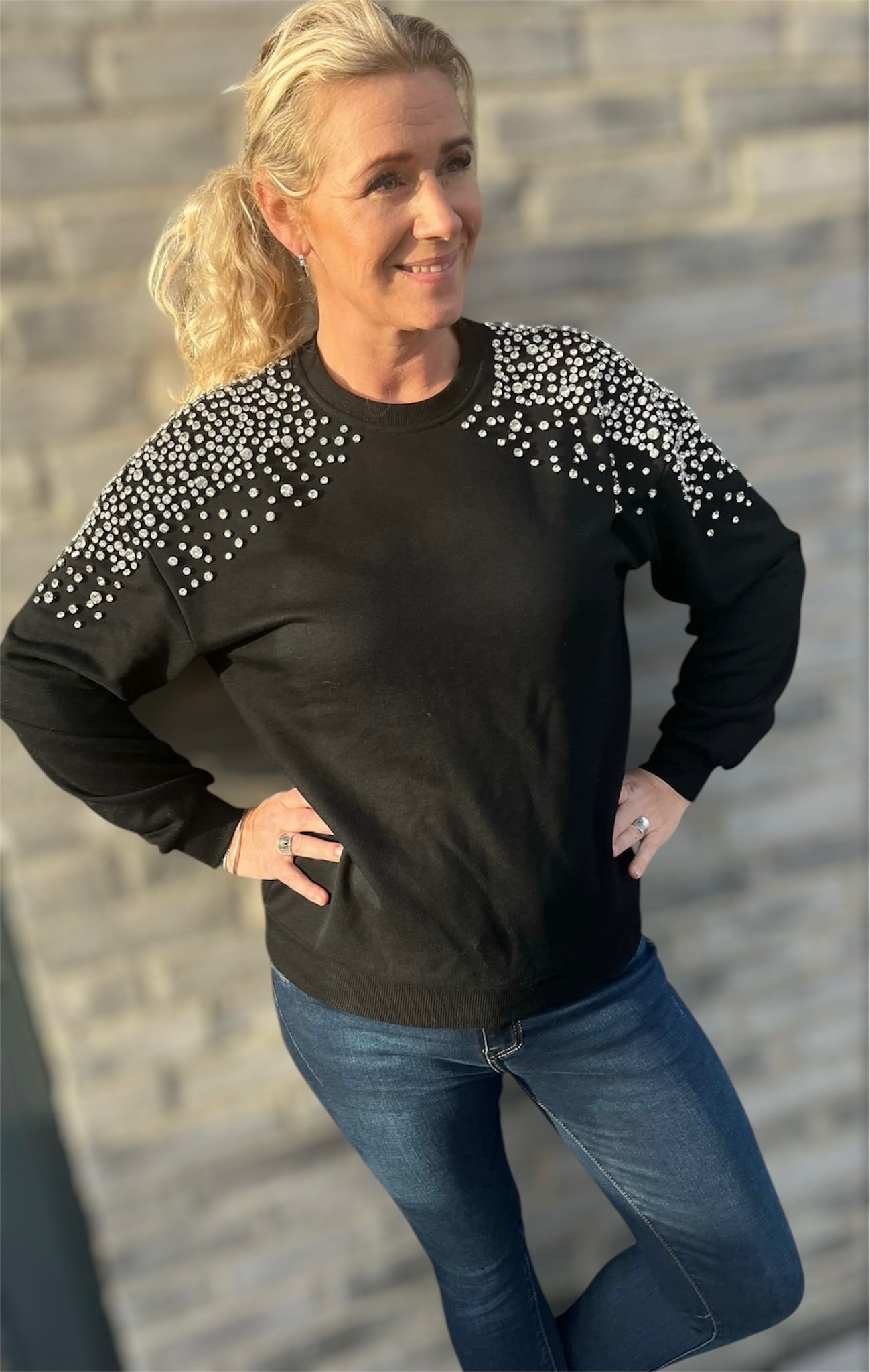Sort sweater med similisten-detaljer fra Spohr Copenhagen, fremhæver elegant design og komfort."​