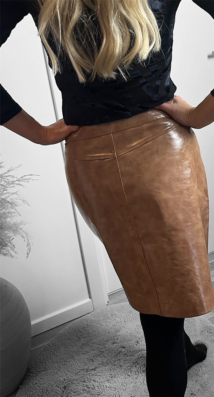 Detaljeret visning af den brune kunstlæder nederdel set bagfra fra Spohr Copenhagen, viser den glansfulde finish 