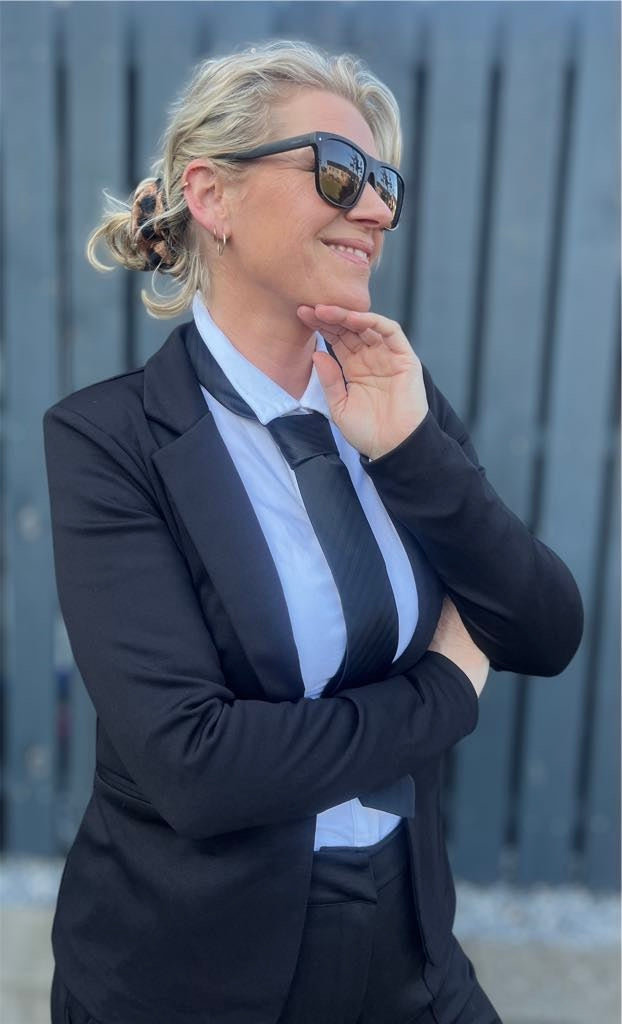 Sort slips til kvinder – klassisk og cool accessorie, stylet med hvid skjorte og sort blazer.