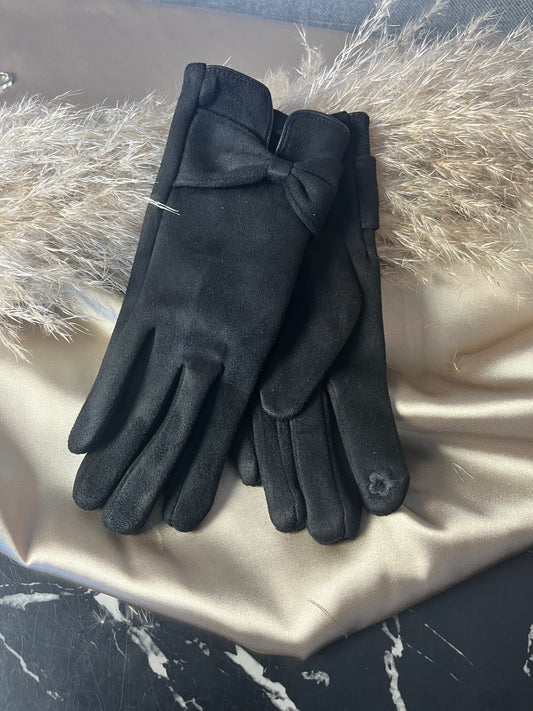 Elegante sorte handsker fra Spohr Copenhagen i blød suede med charmerende sløjfedetalje ved håndleddet – fordi dine hænder fortjener lidt luksus
