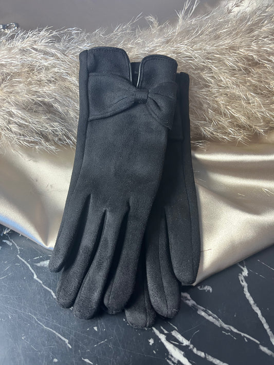 Elegante sorte handsker fra Spohr Copenhagen i blød suede med charmerende sløjfedetalje ved håndleddet – fordi dine hænder fortjener lidt luksus