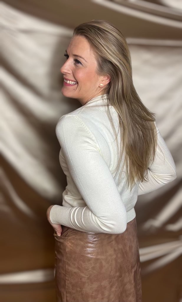 Model iført tætsiddende off-white cardigan set fra siden – en tidløs klassiker til enhver lejlighed.​