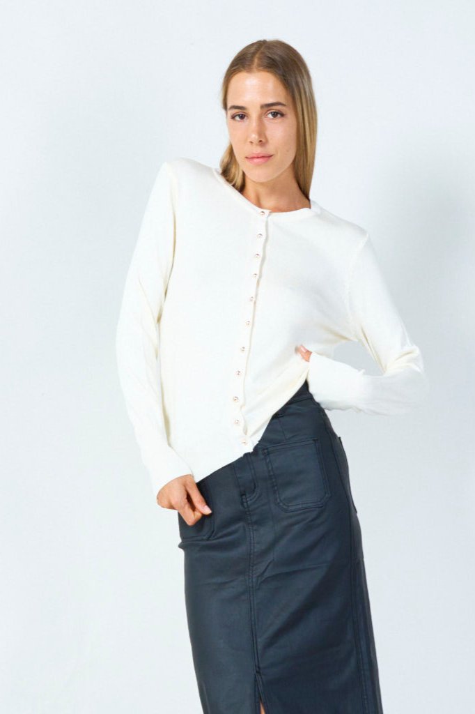 Model iført tætsiddende off-white cardigan med rund hals og elegante knapper – en tidløs klassiker til enhver lejlighed.​